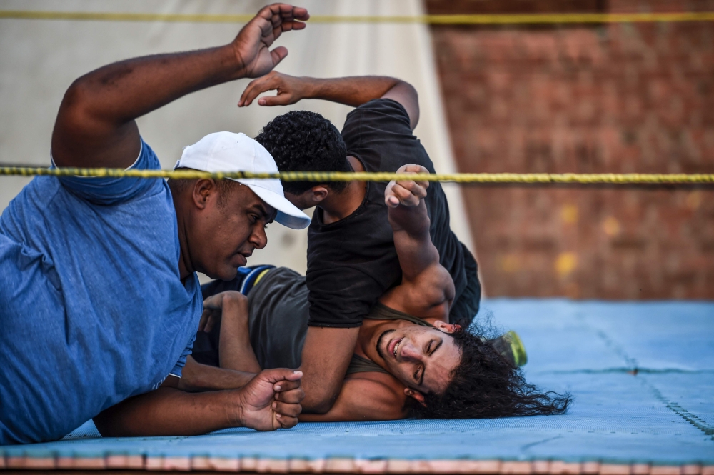Members of the self-declared Egyptian Wrestling Federation (EWR) train in a ring during a session outside the federation founder's home in the village of Serapeum in the Suez canal province of Ismailia. — AFP