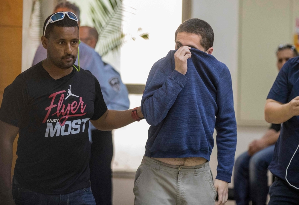 American-Israeli Jewish teenager Michael Ron David Kadar, accused of making dozens of anti-Semitic bomb threats in the United States and elsewhere, is escorted by guards as he leaves the Israeli Justice court in Rishon Lezion in this March 23, 2017 file photo. — AFP