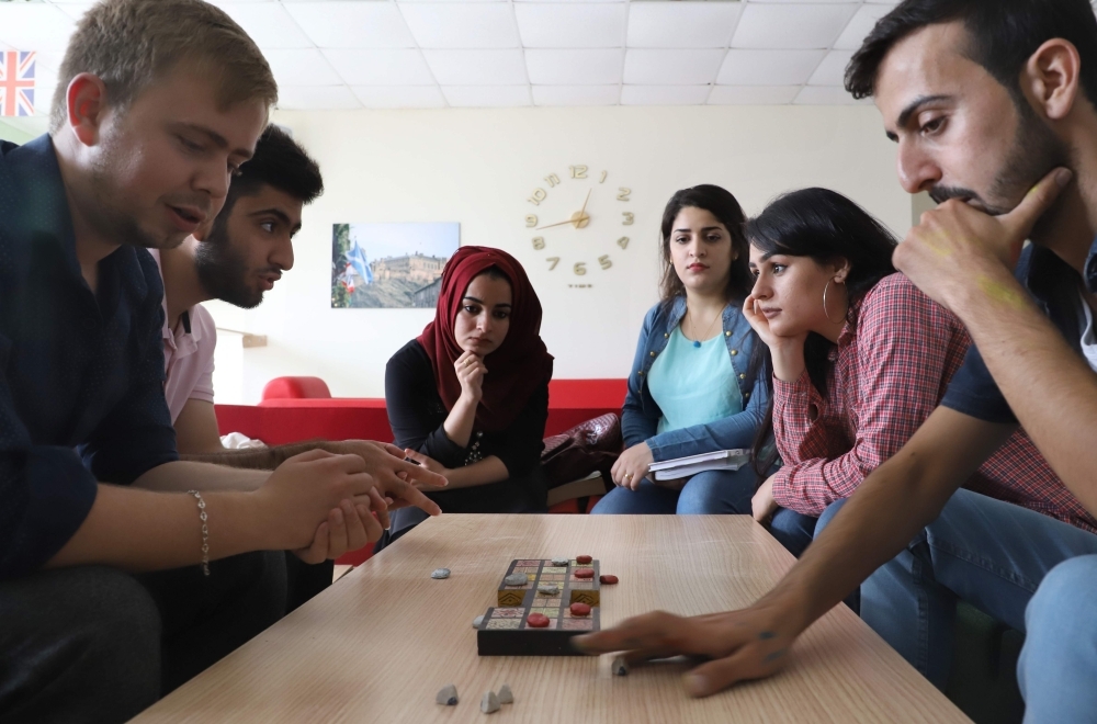 Iraqi artist Hoshmand Mofaq and British archeologist Ashley Barlow (left) play an ancient board game, known as the Royal Game of Ur, in the northern Iraqi city of Raniey. Originating nearly 5,000 years ago in what would become Iraq, the Royal Game of Ur mysteriously died out — until Muwafaq resurrected it by making his own decorated wooden board. — AFP

 / AFP / SHWAN MOHAMMED