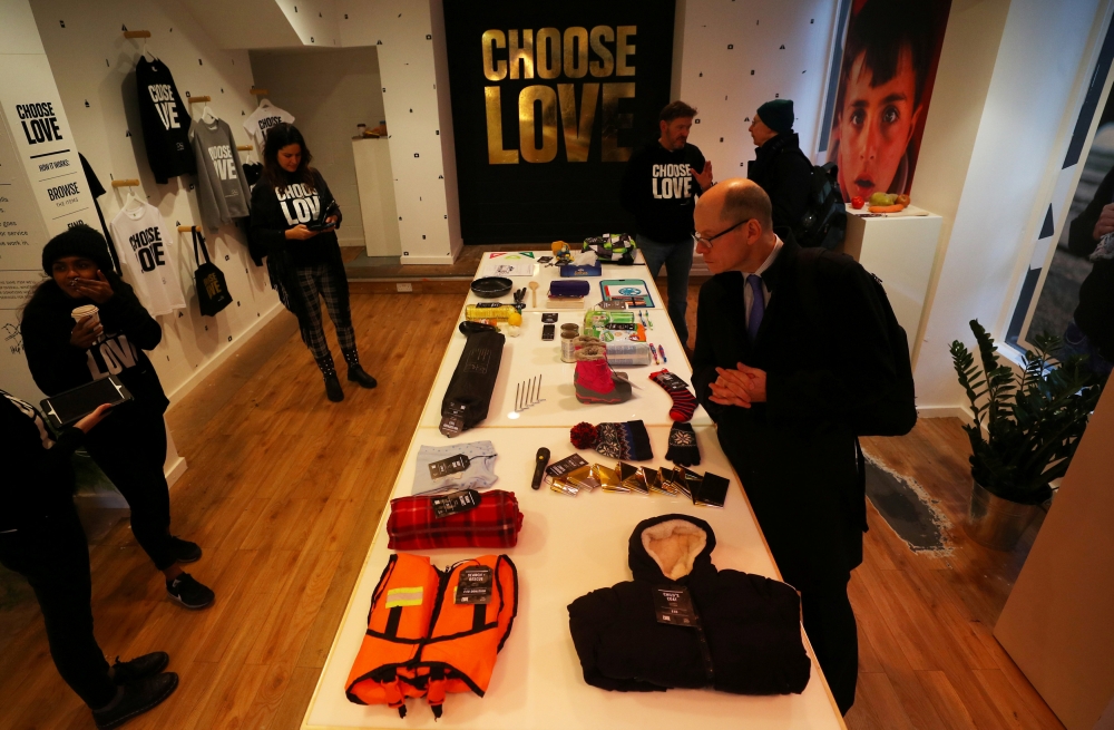 A customer looks at items for sale which represent gifts for refugees at the Choose Love pop-up shop in London, Britain. — Reuters