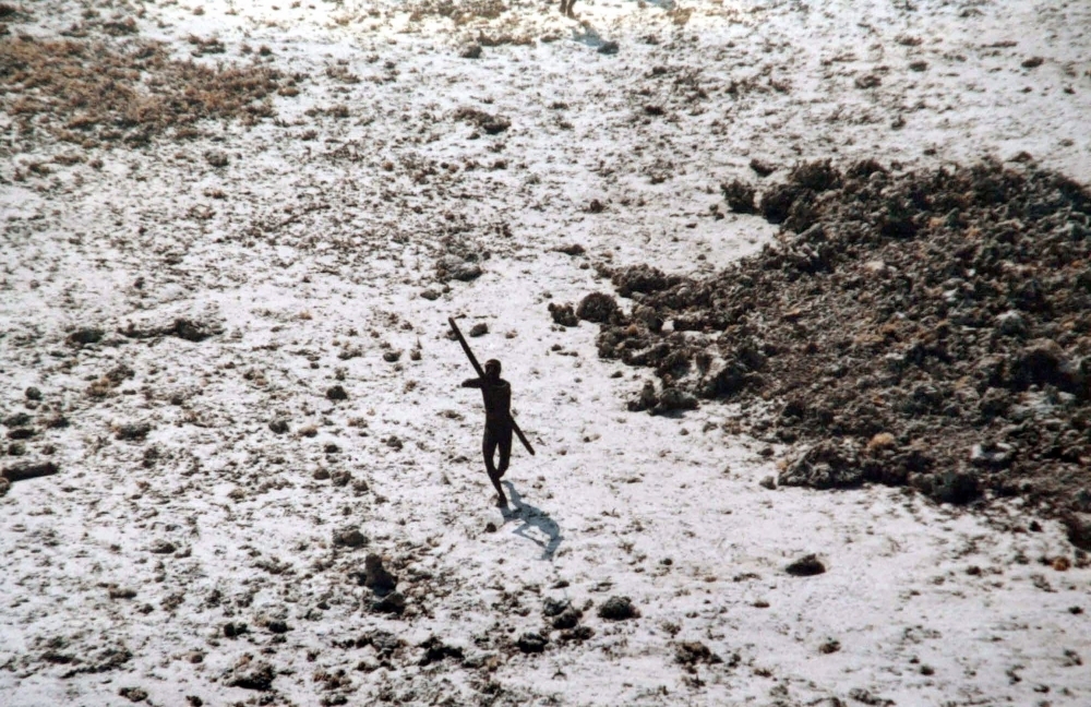 In this handout photo provided by the Indian Coast Guard and Survival International and taken on Dec. 28, 2004, a man with the Sentinelese tribe aims his bow and arrow at an Indian Coast Guard helicopter as it flies over North Sentinel Island in the Andaman Islands, in the wake of the 2004 Indian Ocean tsunami. — AFP