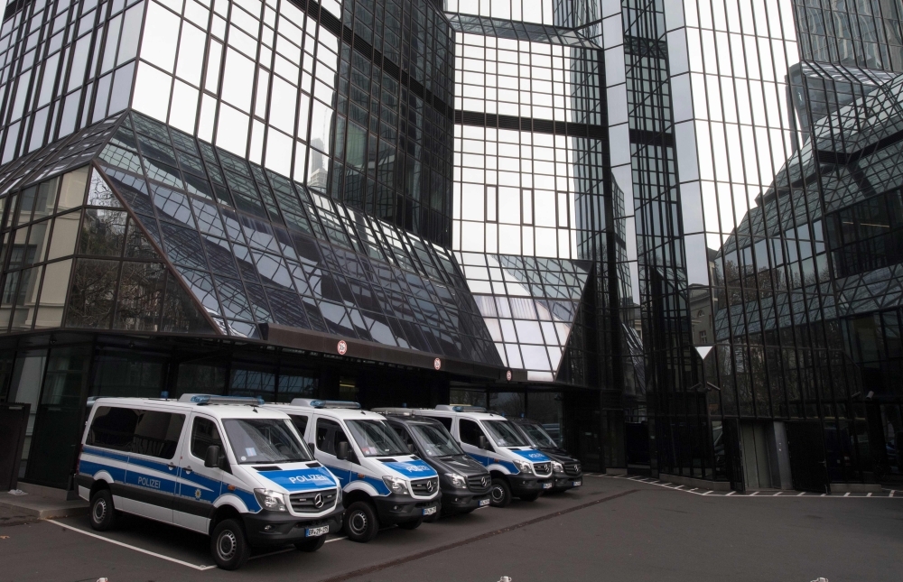 Police vehicles are parked at Deutsche Bank's headquarters in Frankfurt on Thursday. German prosecutors raided several Deutsche Bank offices in the Frankfurt area over suspicions of money laundering based on revelations from the 2016 
