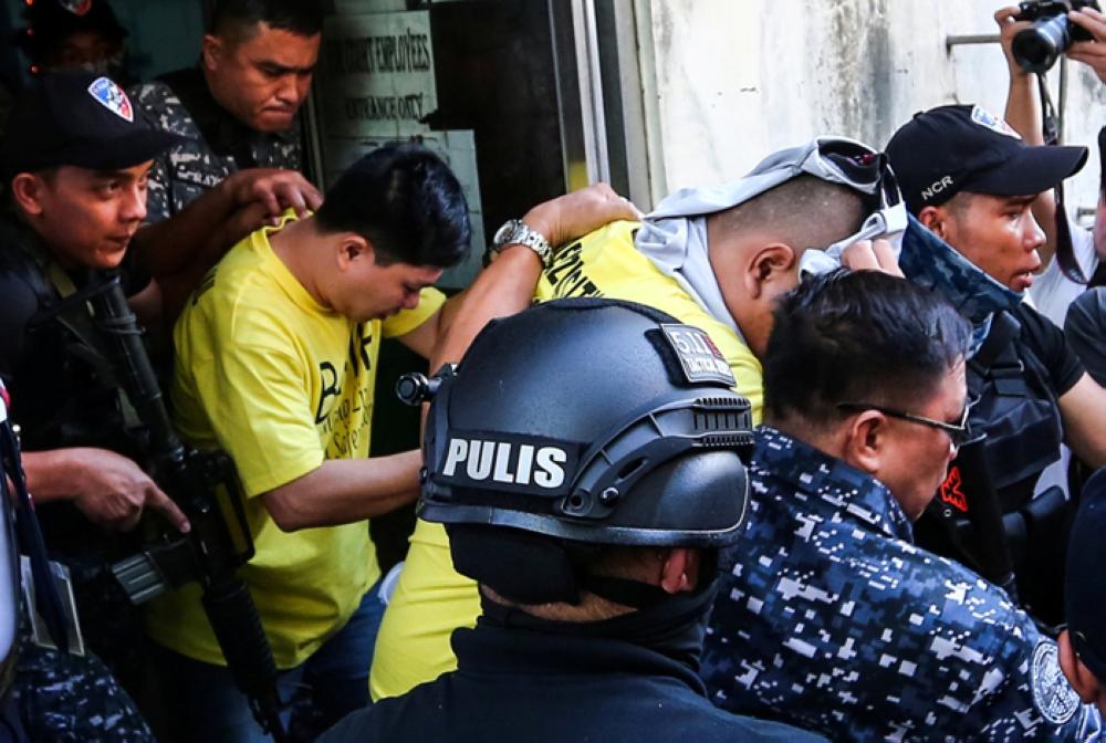 Police officers, the first to be convicted in President Rodrigo Duterte's drugs war, are escorted outside a court after being sentenced for the murder of a 17-year-old high school student, in Manila, Philippines, Thursday. — Reuters
