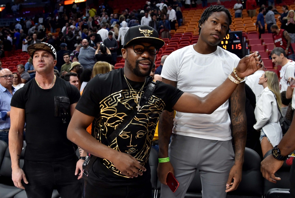 Floyd Mayweather Jr. (left) stands next to former NBA player Archie Goodwin (right).