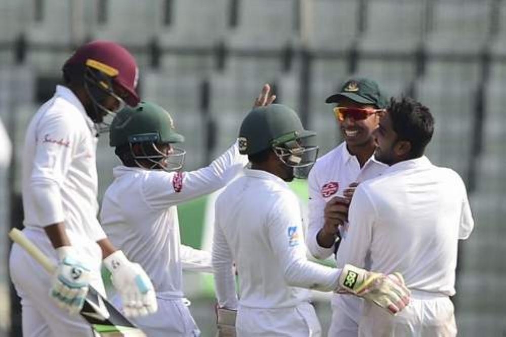 Bangladeshi cricketer Mehidy Hasan (R) celebrates with teammates after the dismissal of West Indies cricketer Devendra Bishoo (L) during the third day of the second Test cricket match at the Sher-e-Bangla National Cricket Stadium in Dhaka on Sunday. — AFP