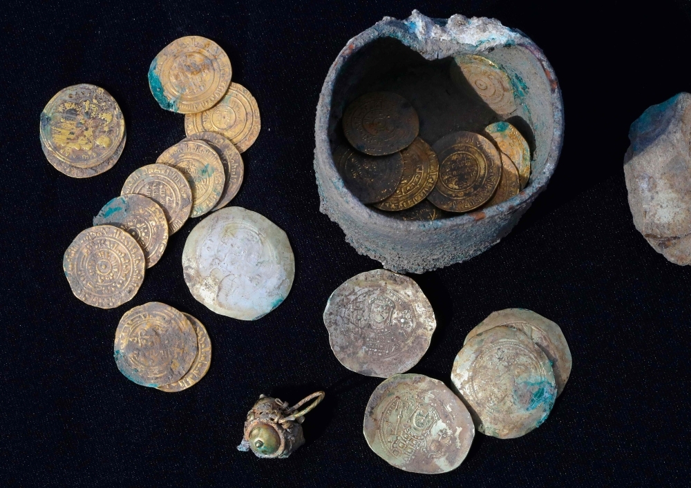 This picture taken on Monday shows recently-uncovered gold coins dating back to the Muslim Fatimid (AD 909-1171) and Byzantine eras (AD 1071-1078) found at the site of an archaeological excavation in the Mediterranean coastal town of Caesarea in north-central Israel. Among the items found at the excavation were 24 rare gold coins, including 18 Fatimid dinars, and six Byzantine coins dating to the reign of emperor Michael VII Doukas. — AFP