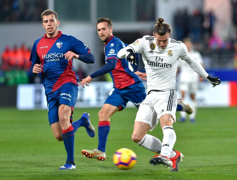 Real Madrid's Gareth Bale (R) kicks the ball during the Spanish league football match against SD Huesca at the El Alcoraz Stadium in Huesca Sunday. — AFP 