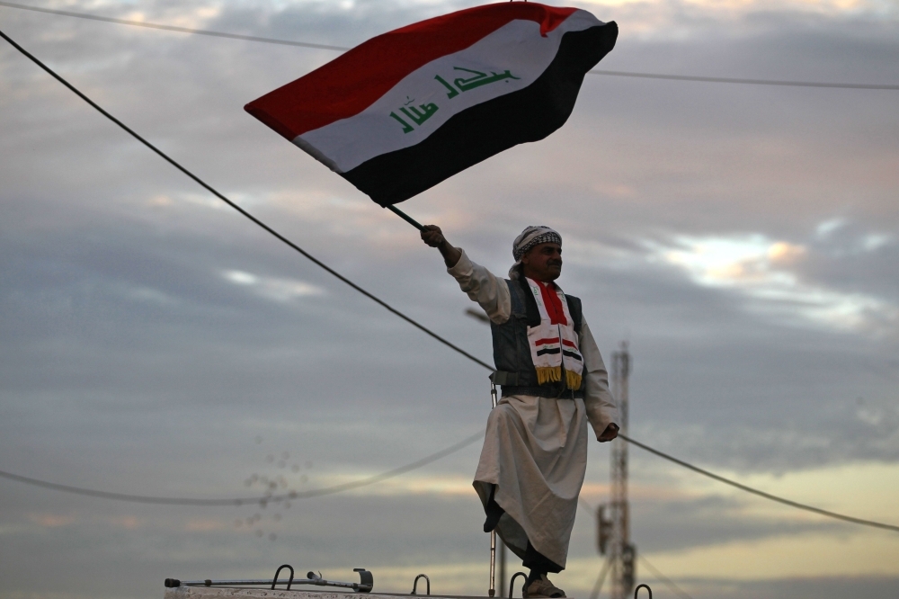 


In this file photo taken on Dec. 10, 2017, an Iraqi man waves his national flag in Baghdad’s Tahrir Square during a gathering to celebrate the end of the three-year war against Daesh (the so-called IS) group. — AFP