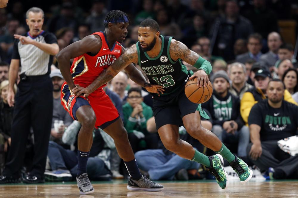 Boston Celtics’ forward Marcus Morris drives against New Orleans Pelicans’ guard Jrue Holiday during their NBA game at TD Garden in Boston Monday. — Reuters