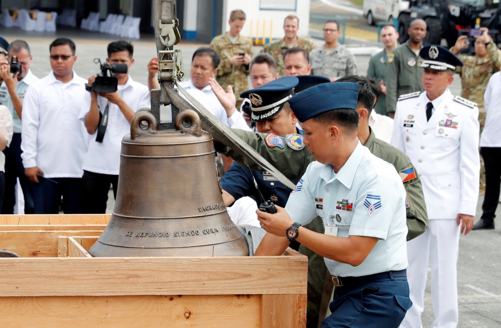 Philippine Air Force personnel unload the bells of Balangiga after their arrival at Villamor Air Base in Pasay, Metro Manila, Philippines, on Tuesday. — Reuters