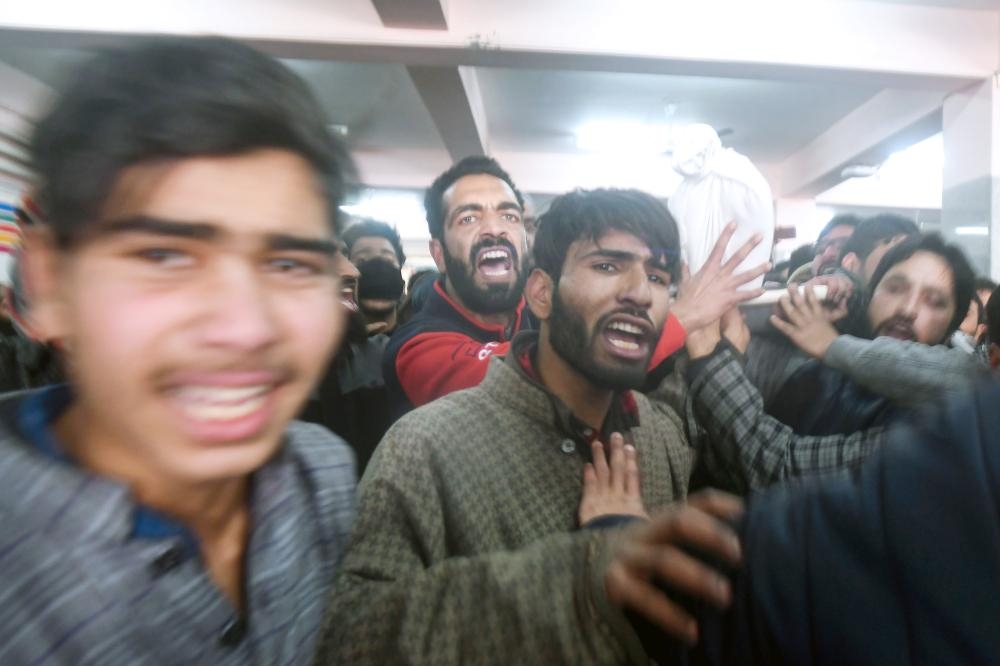 


Kashmiris shout slogans as they carry away the shrouded body of a youth, killed during clashes with authorities, at the main hospital in Srinagar, Saturday. Seven civilians, three armed rebels and a soldier were killed during a gunfight and clashes with protestors in Indian-administered Kashmir, police and hospital authorities said. — AFP