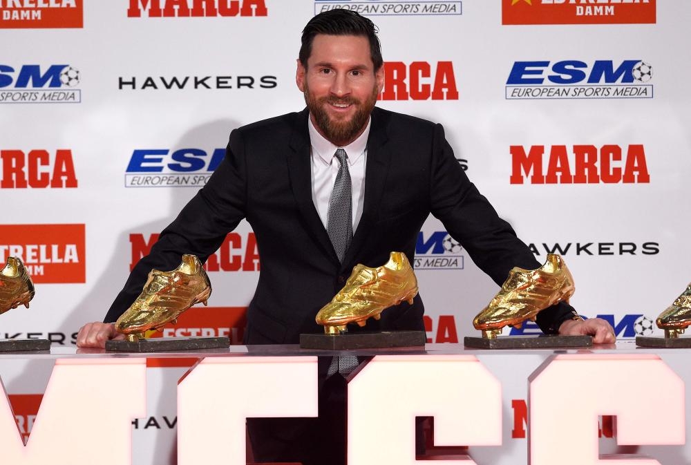 Lionel Messi poses with his five Golden Shoe awards after receiving the 2018 European Golden Shoe honoring the year's leading goalscorer during a ceremony at the Antigua Fabrica Estrella Damm in Barcelona Tuesday. — AFP 