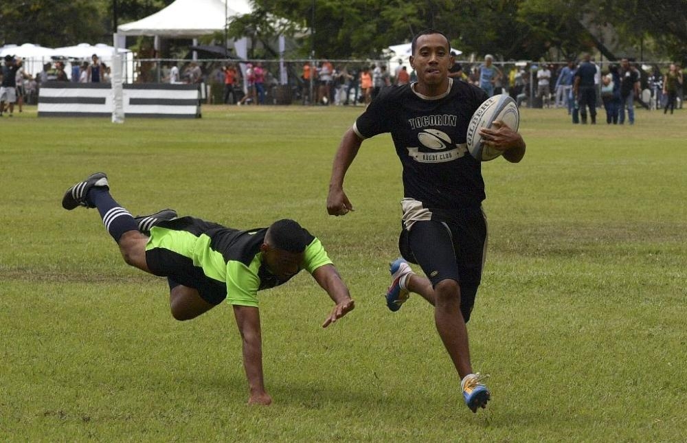 An inmate with the El Tocoron rugby team, right, eludes a prisoner from the rival Centinelas team during the Penitentiary Rugby Tournament in La Victoria, Aragua State, Venezuela, in this file photo. — AFP