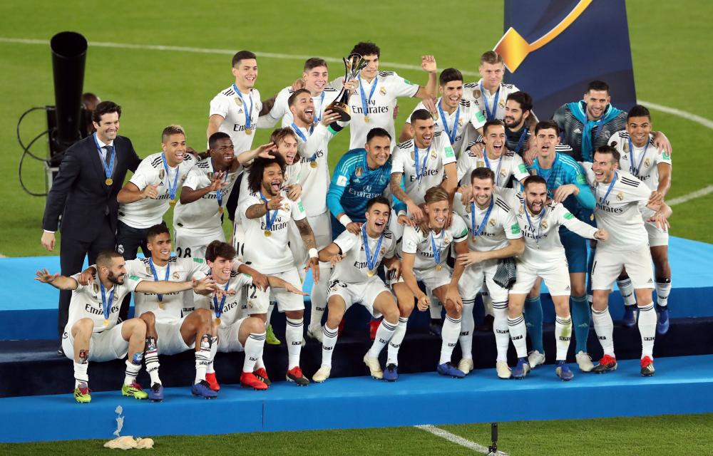 Real Madrid's players celebrate with the trophy after winning the FIFA Club World Cup final against Abu Dhabi's Al Ain at the Zayed Sports City Stadium in Abu Dhabi Saturday. — AFP