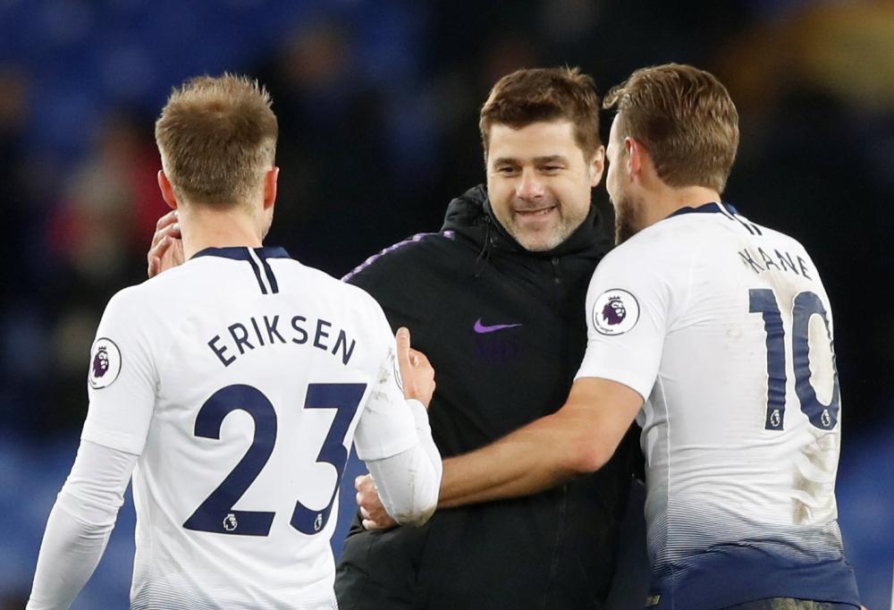 Tottenham's Christian Eriksen and Harry Kane celebrate with manager Mauricio Pochettino after their Premier League match against Everton at Goodison Park, Liverpool, Sunday. — Reuters