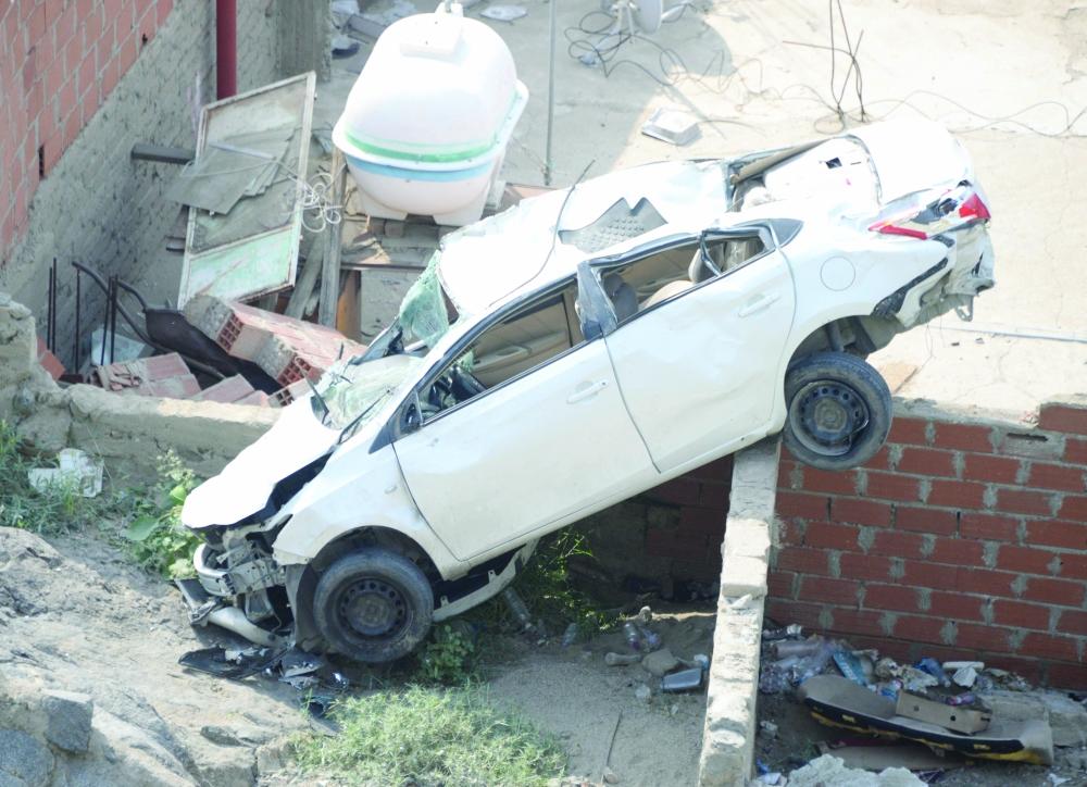 The ill-fated car that ended up on the roof of a house after falling off a mountain road in Ajyad district in Makkah.
