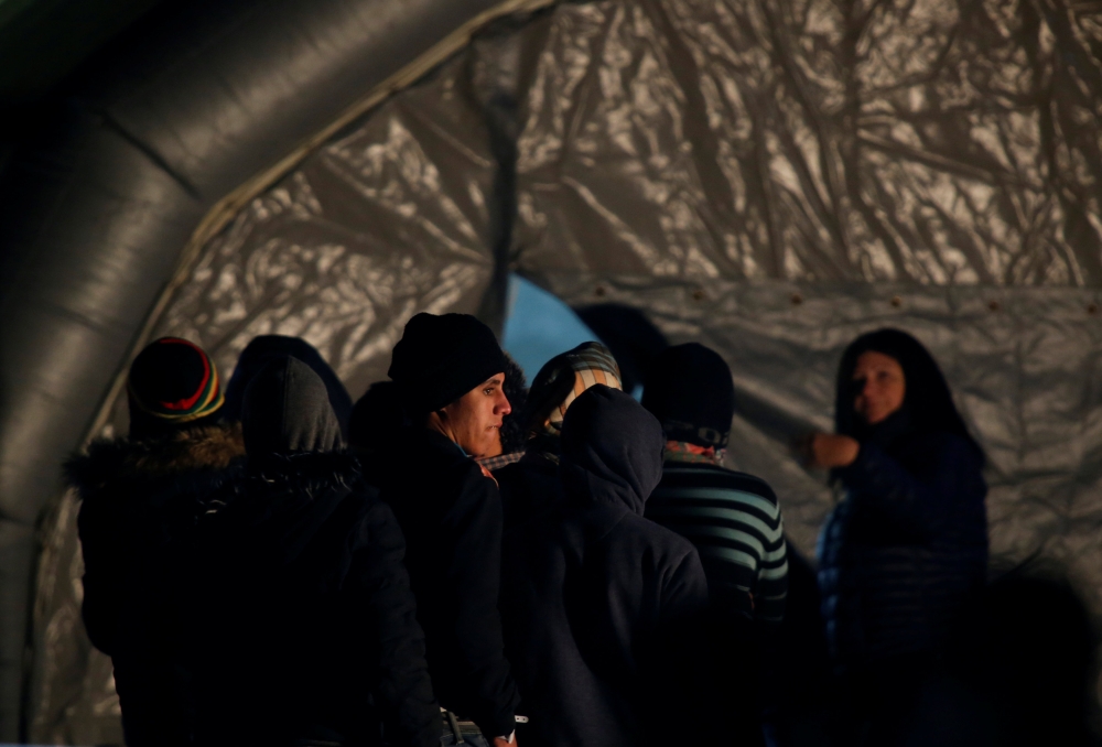 Migrants, part of a group of 69 migrants rescued 117 nautical miles south west of Malta by the Armed Forces of Malta (AFM), wait to be processed after arriving at the AFM Maritime Squadron base in Valletta’s Marsamxett Harbour, Malta, on Sunday. — Reuters