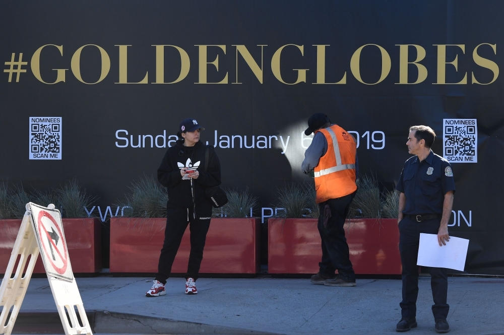 Workers and staff prepare the red carpet area for the 76th Golden Globe Awards at the Beverly Hilton hotel in Beverly Hills, California, to be held on Sunday. — AFP