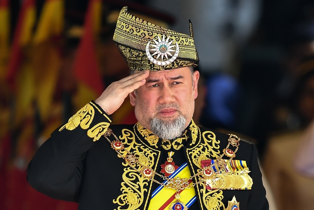 King of Malaysia, Sultan Muhammad V, salutes a royal guard of honor during the opening ceremony of the parliament in Kuala Lumpur in this file photo. — AFP