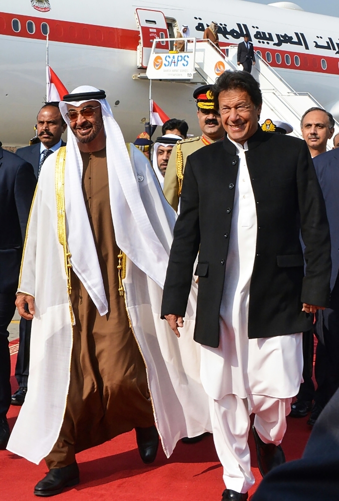 Pakistan's Prime Minister Imran Khan (right) walks with Abu Dhabi's Crown Prince Sheikh Mohamed Bin Zayed Al-Nahyan upon his arrival at the military Nur Khan Air Force base in Islamabad, Sunday.  — AFP