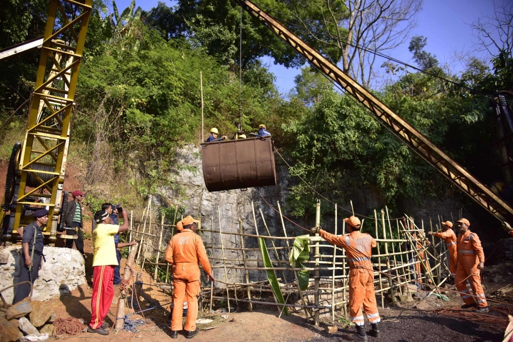 Indian National Disaster Response Force (NDRF) personnel gather around a crane as Indian Navy divers are lifted with a pulley during rescue operations to help 15 miners trapped by flooding in an illegal coal mine in Ksan village in Meghalaya’s East Jaintia Hills district in this Dec. 29, 2018 file photo. — AFP