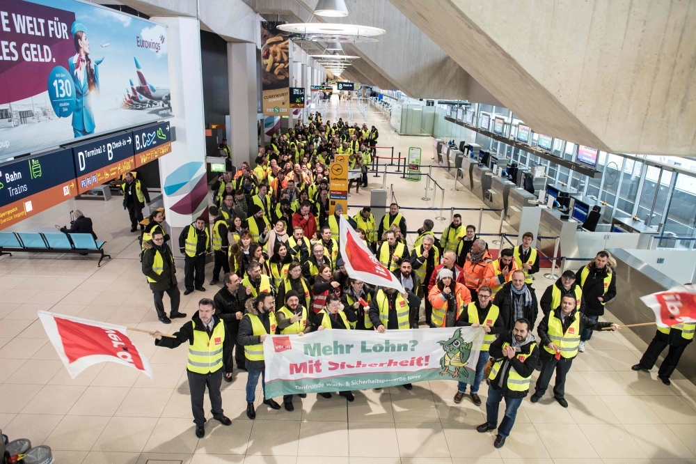 Members of Germany’s Verdi union hold flags and banners at a terminal during a one-day strike by security staff at Cologne’s airport on Thursday. — AFP