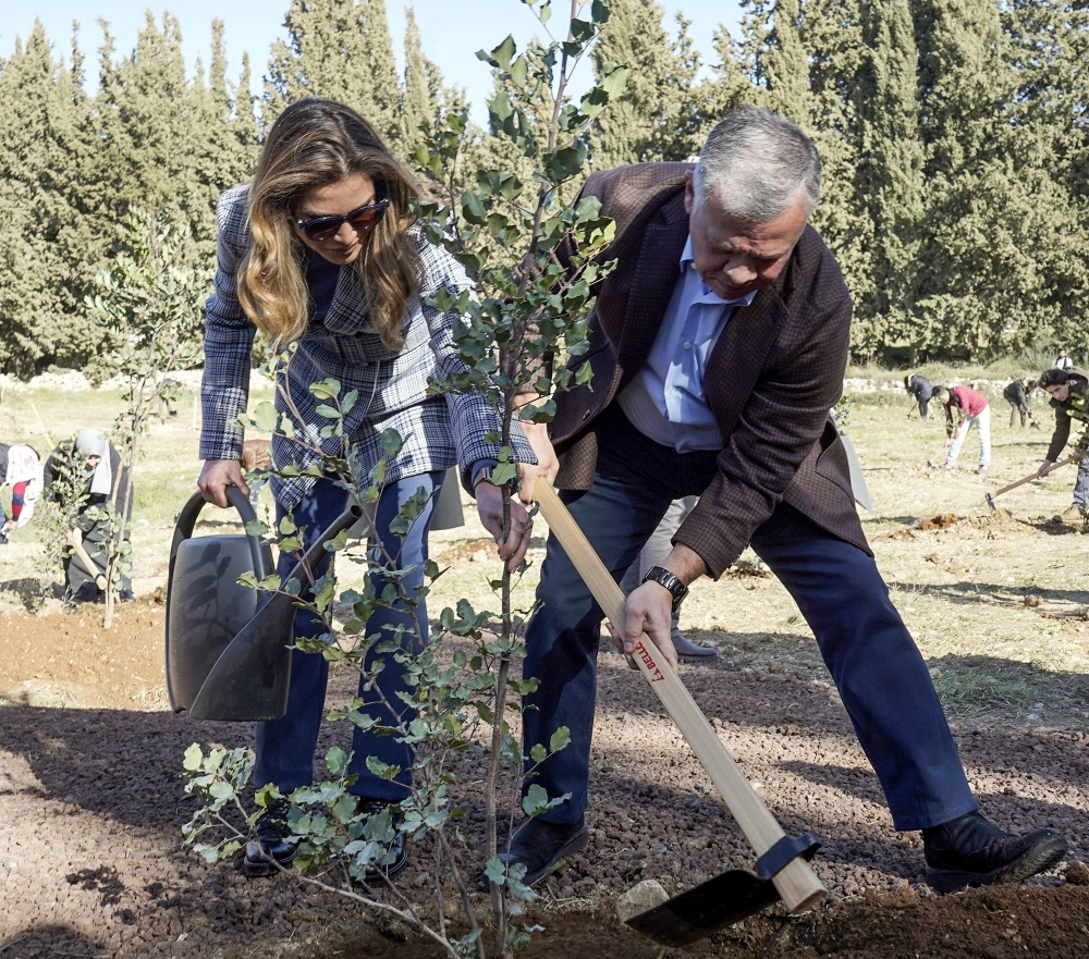 A handout picture released by the Jordanian Royal Palace on Tuesday shows Jordan’s King Abdullah II and his wife Queen Rania planting tree saplings on the occasion of Arbour Day at Al-Kamaliya forest in Amman. — AFP