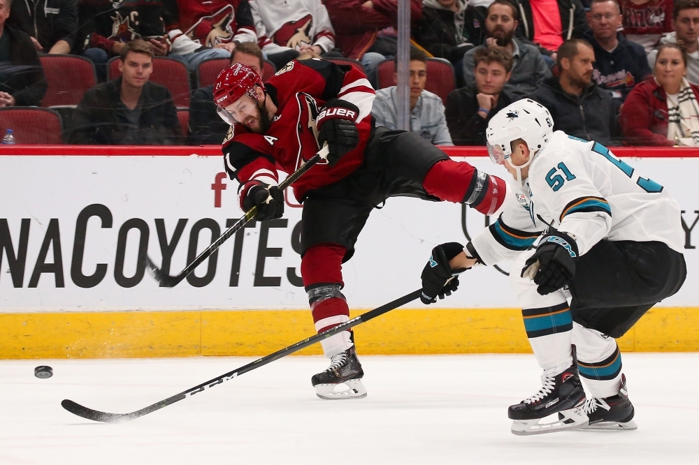 Derek Stepan No. 21 of the Arizona Coyotes shoots the puck past Radim Simek No. 51 of the San Jose Sharks during the first period of the NHL game at Gila River Arena on Wednesday in Glendale, Arizona. — AFP