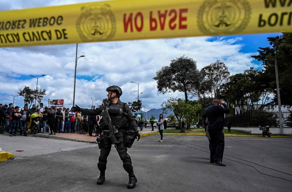 Security forces stand guard at the site of an explosion at a police academy in Bogota on Friday. — AFP