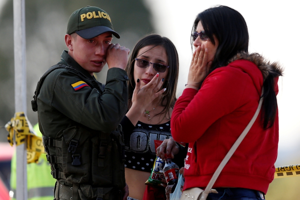 Security forces stand guard at the site of an explosion at a police academy in Bogota on Friday. — AFP