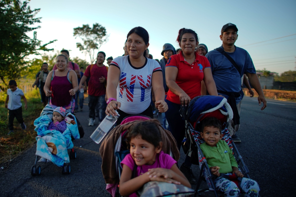 Migrant Celena Mejia, center, from Honduras, pushes a cart with her six-year-old daughter during their journey toward the United States, in the outskirts of Ciudad Hidalgo, Mexico, on Friday. — Reuters
