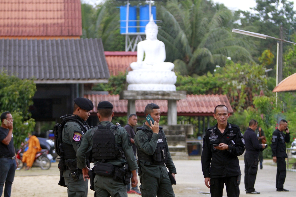 Military police officers are seen at a temple where unknown gunmen shot dead two Buddhist monks and injured two others on Friday in Su-ngai Padi district in the southern province of Narathiwat in Thailand. — Reuters