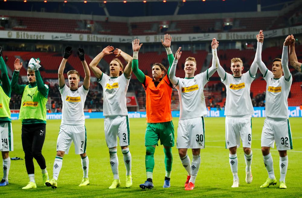 Borussia Monchengladbach players celebrate after the Bundesliga match against Bayer Leverkusen at BayArena, Leverkusen, Saturday. — Reuters