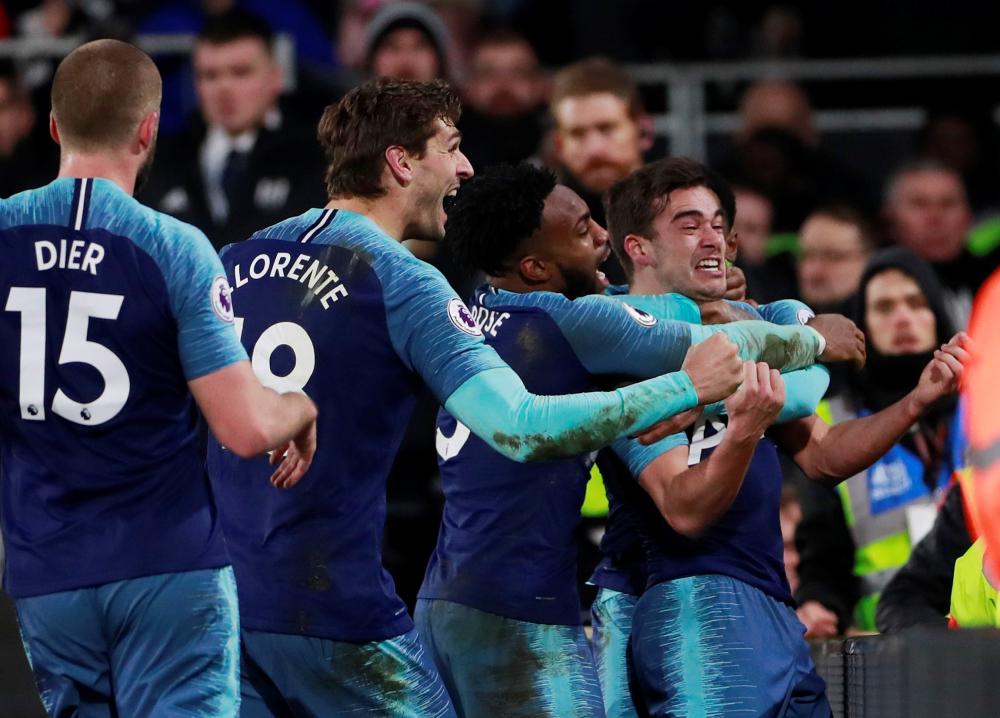 Tottenham's Harry Winks celebrates scoring their second goal against Fulham with Danny Rose and teammates during their Premier League match at Craven Cottage, London, Sunday. — Reuters