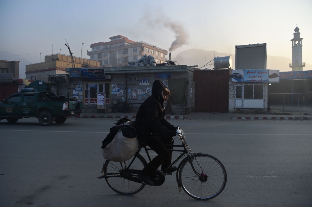 An Afghan resident rides a bicycle along a road amid heavy smog conditions in Kabul in this Jan. 17, 2019 file photo. — AFP