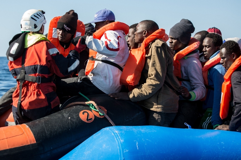 A group of 47 migrants is helped by a Sea Watch 3 crew member, left, during their transfer from a rescued unflatable boat onto a Sea Watch 3 RHIB (Rigid Hull Inflatable Boat) during a rescue operation by the Dutch-flagged vessel Sea Watch 3 off Libya’s coasts in this Jan. 19, 2019 file photo. — AFP