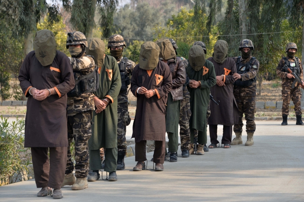 Forces with Afghanistan’s National Directorate Security (NDS) escort alleged Taliban fighters after they are presented to media in Jalalabad on Wednesday. — AFP