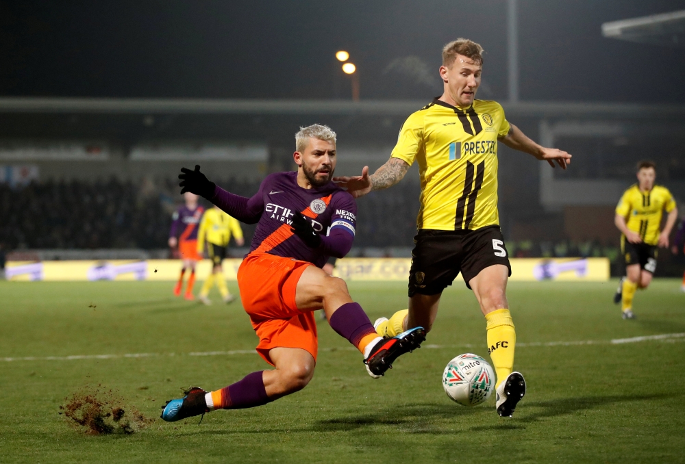 Manchester City's Sergio Aguero in action with Burton Albion's Kyle McFadzean during the Carabao Cup second-leg semifinal at the Pirelli Stadium, in Burton-on-Trent, Britain, on Wednesday.  — Reuters