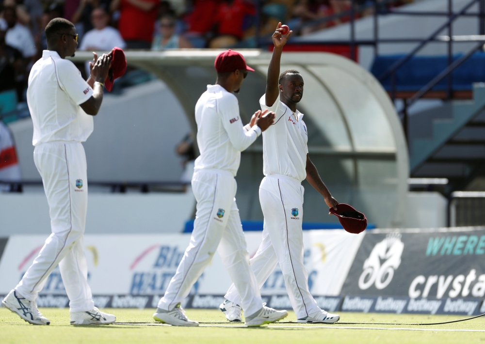 West Indies' Kemar Roach acknowledges the cheers by holding the ball in the air after wrecking England's first innings on the second day of the First Test at the Kensington Oval, Bridgetown, Barbados, on Thursday.  — Reuters