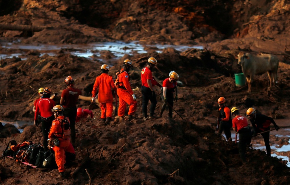 Members of a rescue team search for victims after a tailings dam owned by Brazilian mining company Vale SA collapsed, in Brumadinho, Brazil on Monday. — Reuters