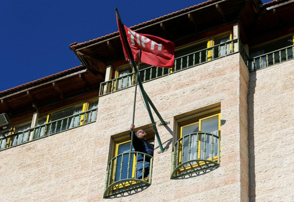 A staff fixes the flag of Temporary International Presence in Hebron (TIPH) at its headquarters in Hebron, in the Israeli-occupied West Bank, Tuesday. — Reuters 