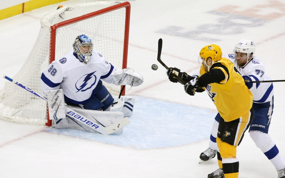 Pittsburgh Penguins right wing Bryan Rust (17) attempts to bat the puck out of the air as Tampa Bay Lightning goaltender Andrei Vasilevskiy (88) and defenseman Victor Hedman (77) defend during the second period at PPG PAINTS Arena. Pittsburgh won 4-2. — Reuters
