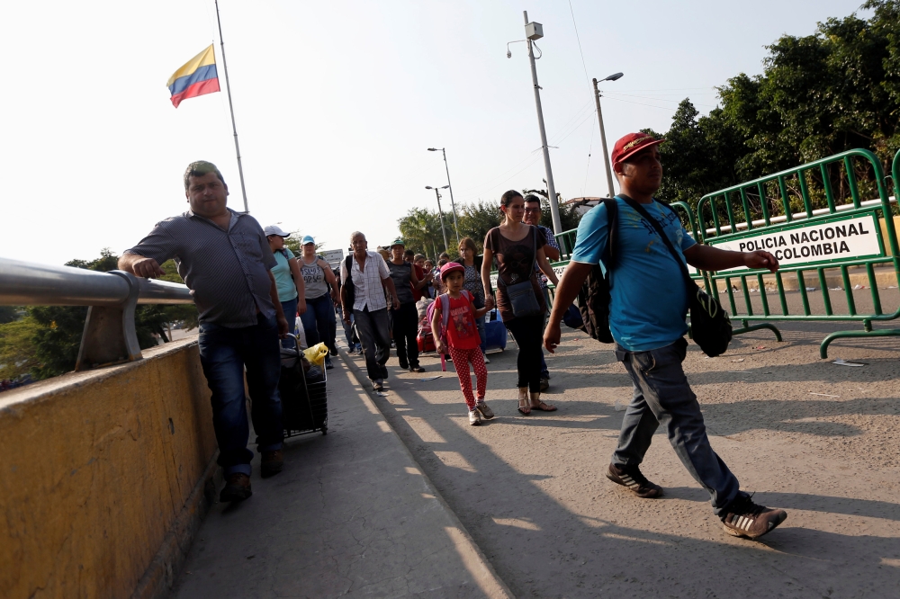 People cross into Venezuela over the Simon Bolivar international bridge in Cucuta, Colombia, on Sunday. — Reuters