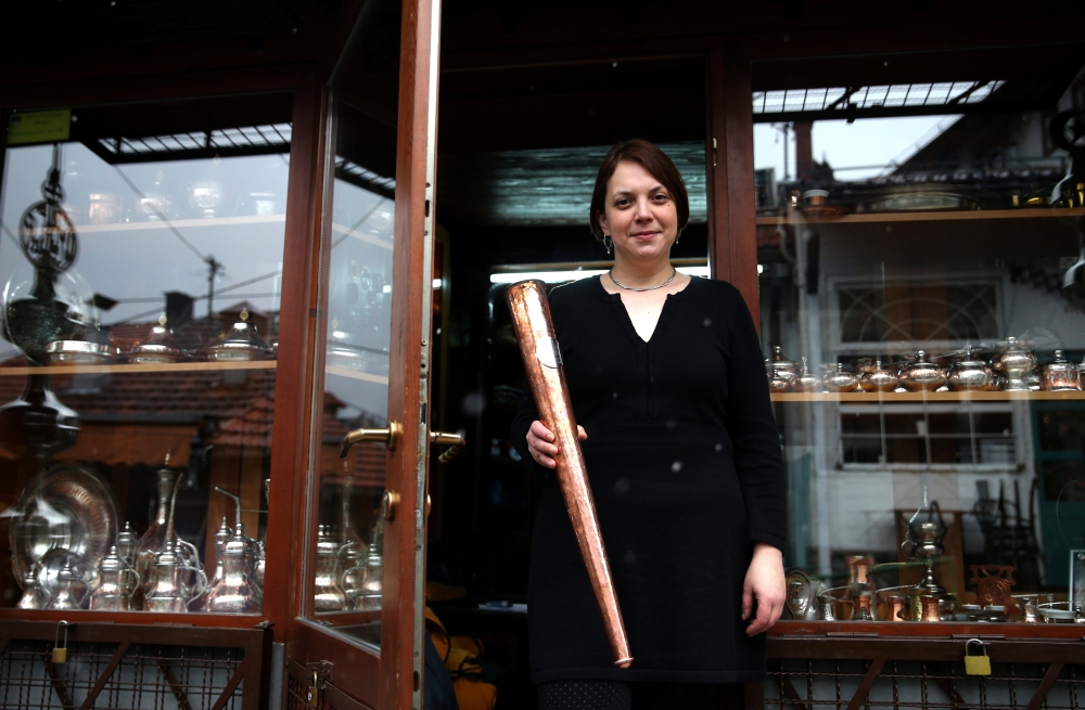 Nermina Alic, poses for a photo with the Olympic flame torch that she designed for the upcoming European Youth Olympic Winter Festival in Sarajevo, Bosnia and Herzegovina Monday. — Reuters