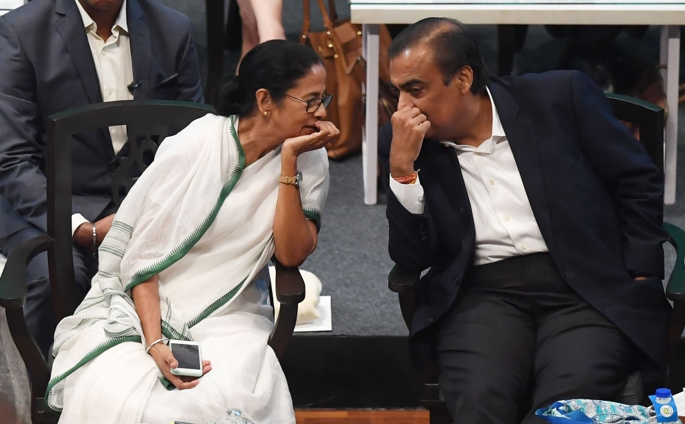 Indian Chief Minister of West Bengal state Mamata Banerjee (L) speaks with businessman Mukesh Ambani (R) at the Bengal Global Business Summit 2019 in Kolkata on Thursday. — AFP