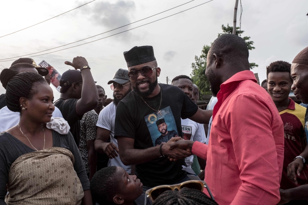 Modern Democratic Party (MDP) candidate US-Nigerian musician Olubankole Wellington popularly known as Banky W. shakes hand with supporters during a campaign rally at Ajah in Lagos.  Banky W. was born in the United States to Nigerian parents — an engineer father and church pastor mother. Banky W. hopes to win a seat in the House of Representatives for the Modern Democratic Party (MDP), which was only created last year. — AFP