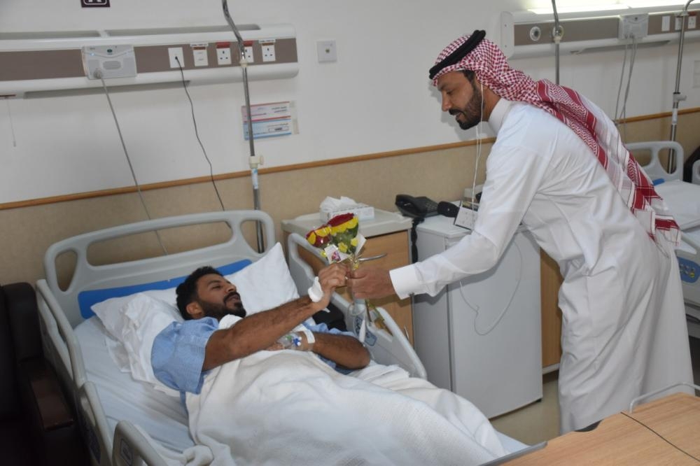 A member of the media delegation presents a gift to one of the patients at King Fahd Hospital in Jeddah.