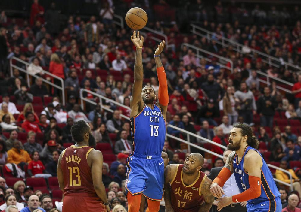 Oklahoma City Thunder’s forward Paul George shoots the ball as Houston Rockets guard James Harden (L) and forward PJ Tucker defend during their NBA at Toyota Center in Houston Saturday. — Reuters 