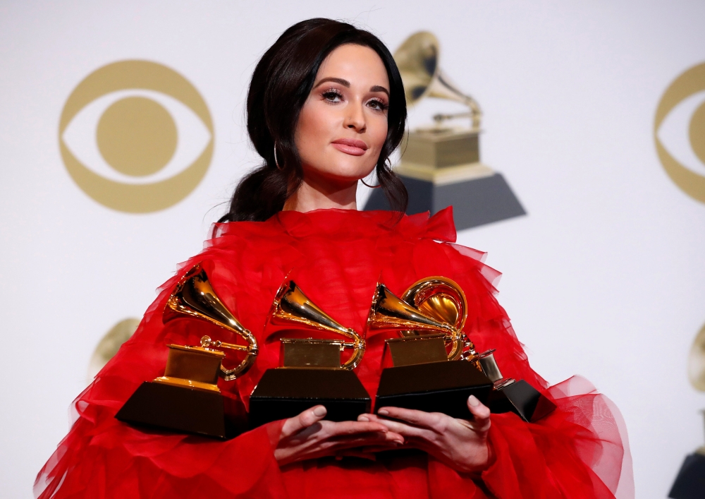 Lady Gaga poses backstage with her awards for Best Song Written for Visual Media and Best Pop Duo/Group Performance for 