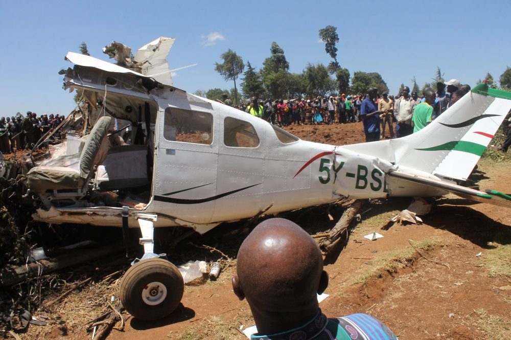 Rescuers and bystanders gather near the wreckage of a Cessna 206 light aircraft that crashed with its Kenyan pilot and four foreign passengers at an agricultural farm in Londiani, Kericho county, Kenya, on Wednesday. — Reuters